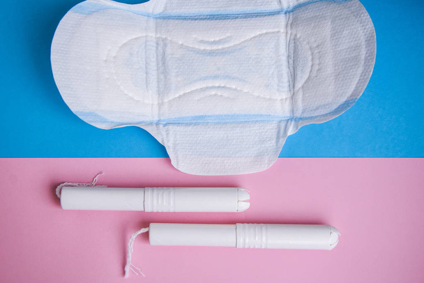 Higiénikus tamponok és párna kék és rózsaszín háttérrel. másolás hely, menstruáció egészségügyi pad és tampon női higiéniai védelem. Kritikus napok. Orvosi fogantatás a kék háttér, napi, menstruációs nő - Fotó, kép