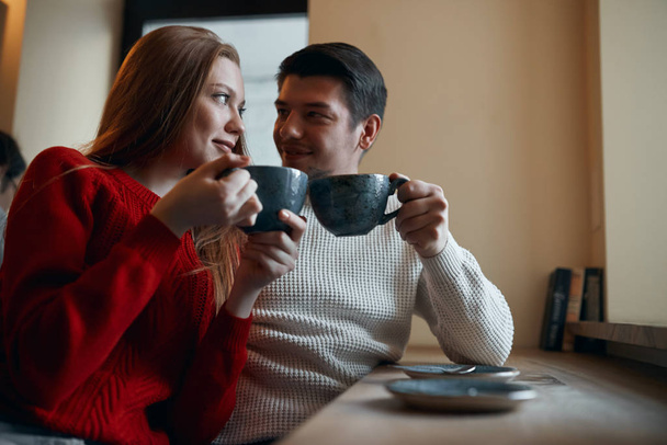 romantic couple sitting at the table enjoying hot tea - Фото, зображення