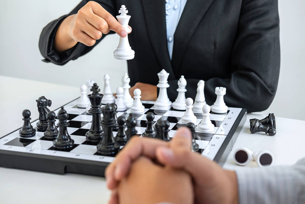 Oyuncularla, iş adamlarıyla ve iş kadınlarıyla, rakip oyuncularla rekabet içinde satranç figürlerini hareket ettirmeye yönelik strateji düşünen ve kazanmak için oynamayı planlayan siyah-beyaz satranç. - Fotoğraf, Görsel