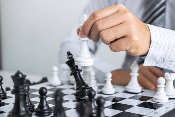 Xadrez preto e branco com o jogador, Mãos de homem de negócios pensando em mover a figura do xadrez na competição e planejando estratégia para o sucesso jogar para ganhar
. - Foto, Imagem