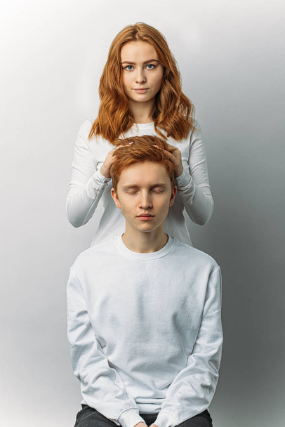 portrait of careful woman touching mans red hair - Foto, afbeelding