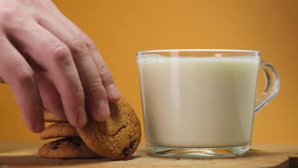 Chocolate cookies on wooden boar and glass of milk. Close up - Imágenes, Vídeo