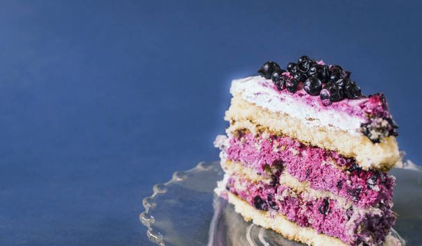 Кусок черничного пирога на голубом фоне. селективный фокус
. - Фото, изображение