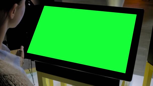 Groen scherm concept - vrouw op zoek naar lege interactieve groene display kiosk - Video