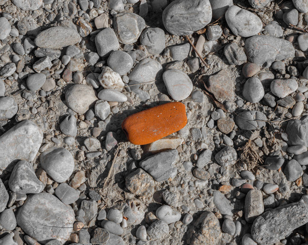 Una pietra rossa su un terreno pietroso
 - Foto, immagini