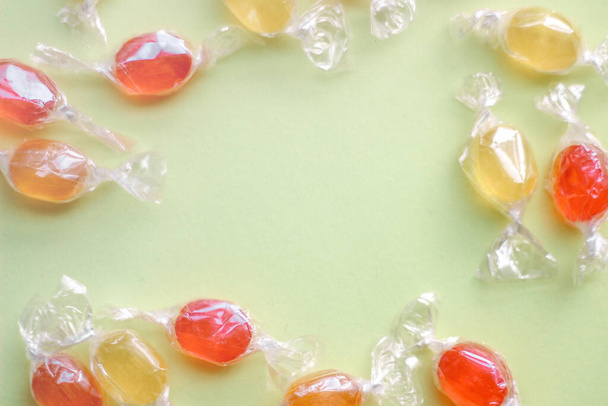 een frame van zoetgekleurde snoeplolly 's op een lichtgele achtergrond. Concept van het ontwerp van speelgoed voor kinderen - Foto, afbeelding
