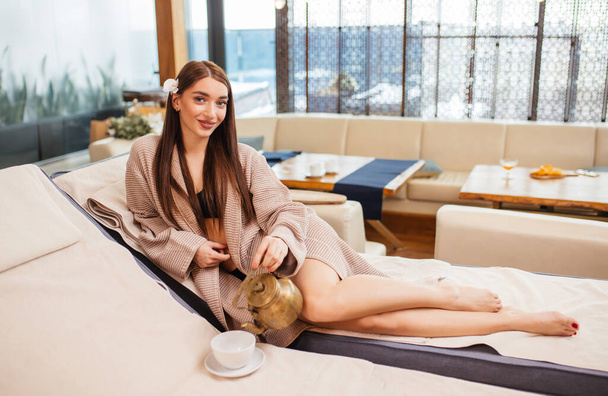 young good-looking caucasian woman drinking tea in spa salon - Photo, image