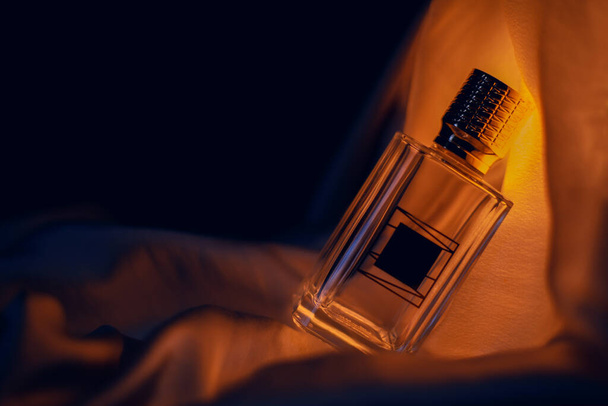 θηλυκό μπουκάλι άρωμα σε ζεστούς τόνους  - Φωτογραφία, εικόνα