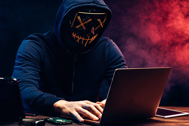 młody cyberprzestępca włamujący się do laptopa - Zdjęcie, obraz