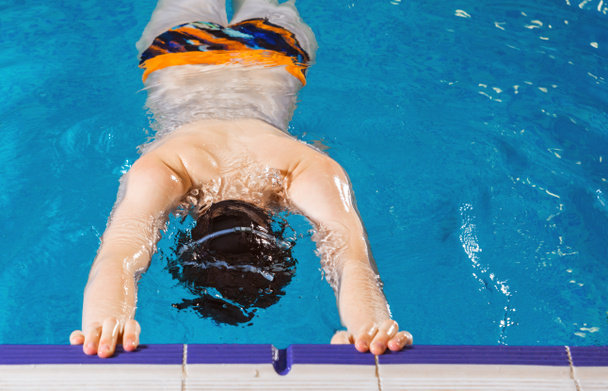 Niño preadolescente nadando en la piscina cubierta durante la clase de natación
 - Foto, Imagen