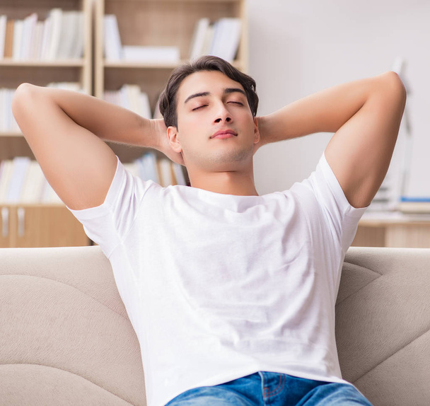 Young man relaxing sitting in couch sofa - Φωτογραφία, εικόνα