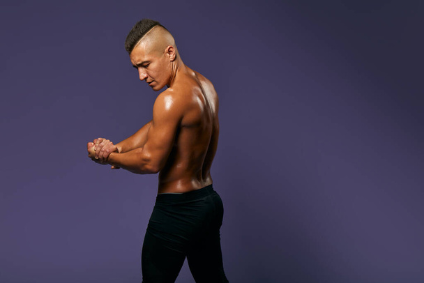 Strong handsome stylish athletic man showing biceps and muscular body - Φωτογραφία, εικόνα
