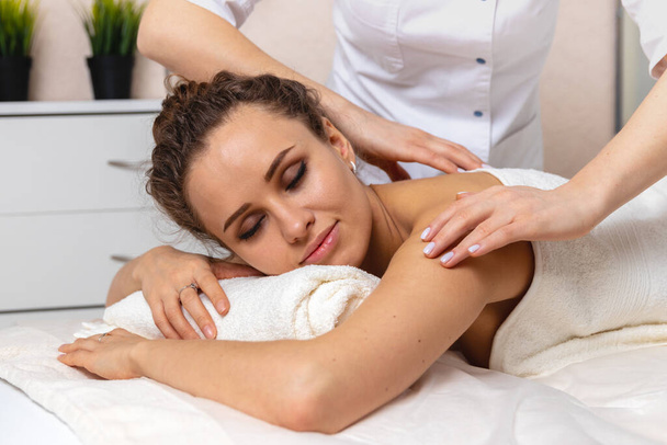 close-up body care in spa salon for young woman, beautiful girl with closed eyes enjoying treatment procedure and back massage, concept of beauty and cosmetology - Valokuva, kuva