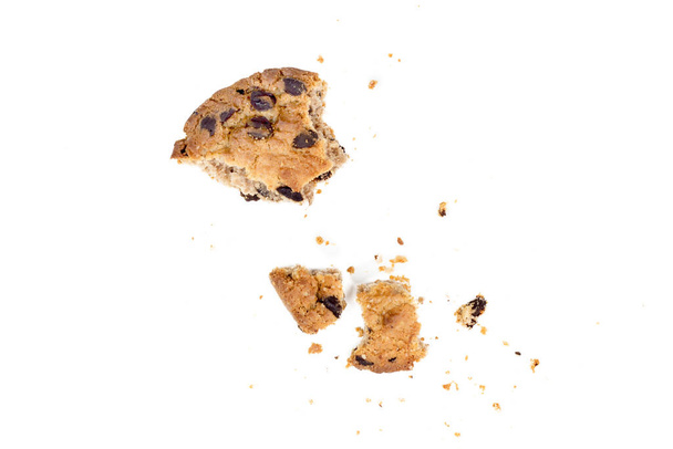 Primo piano di pezzi di biscotti con gocce di cioccolato con briciole isolate su sfondo bianco - Foto, immagini