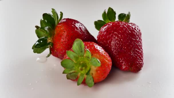 Water poured on a strawberry on a white background. - Footage, Video