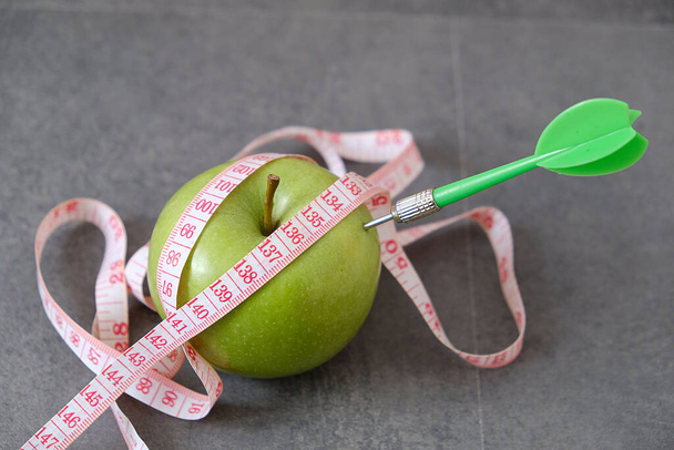 maçã verde e fita métrica e dardo, a ser comprometida com a perda de peso
, - Foto, Imagem