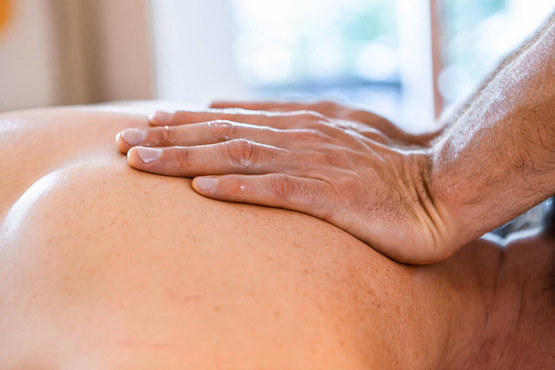 Sports physiotherapist massaging muscular strong man - Foto, Imagem