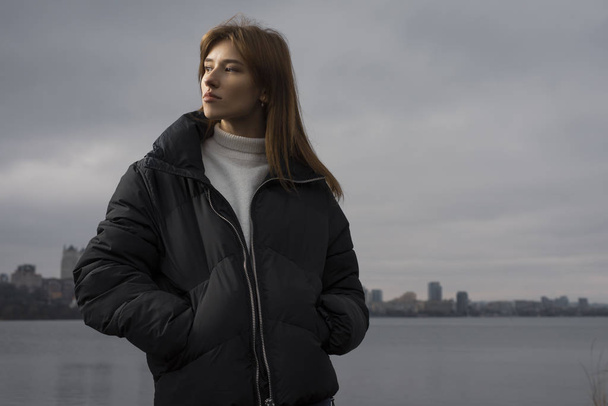 Portrait of woman in winter wear against city background - Photo, image
