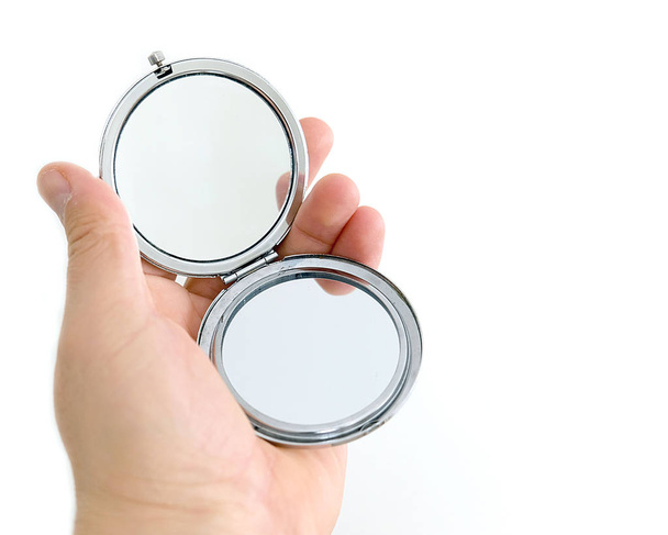 кишенькове дзеркало в руці людини на білому тлі
 - Фото, зображення