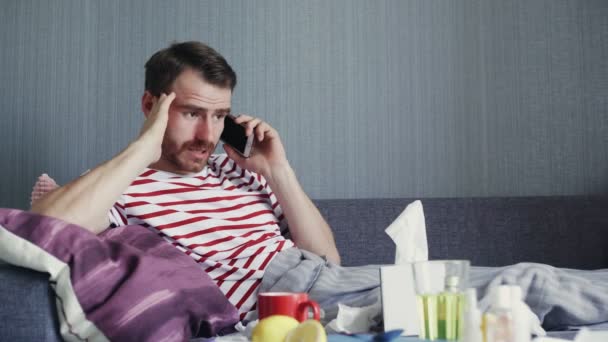Άρρωστος νεαρός μιλάει στο τηλέφωνο στο σπίτι - Πλάνα, βίντεο