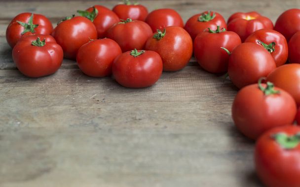 Tuoreet, punaiset tomaatit vanhalla puupohjalla, tilaa tekstille
 - Valokuva, kuva