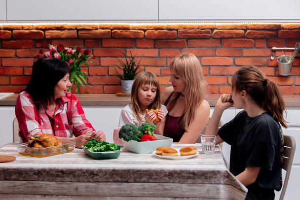 бабушка, мать и внучки проводят время на кухне
 - Фото, изображение