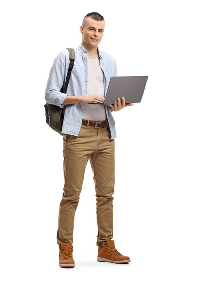 Full length portrait of a male student standing and using a laptop computer isolated on white background - Foto, Imagem