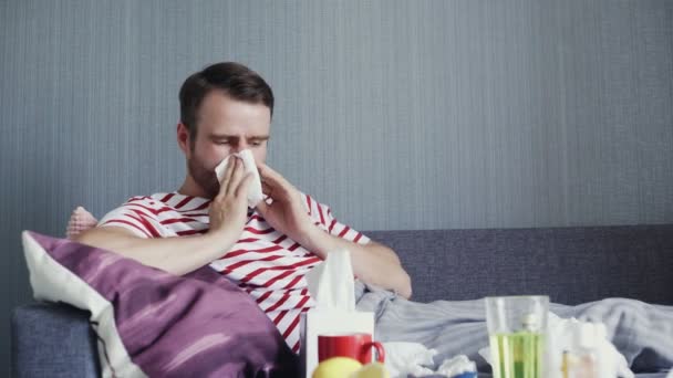 Un hombre tose pesadamente, sonándose la nariz mientras está sentado en un sofá en la sala de estar
 - Imágenes, Vídeo