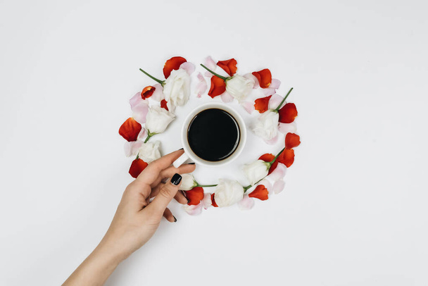 round frame of flowers and female hand taking coffee cup - Fotoğraf, Görsel