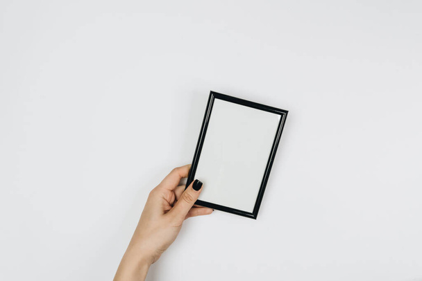 woman holding a blank frame on a white background - Foto, Imagen