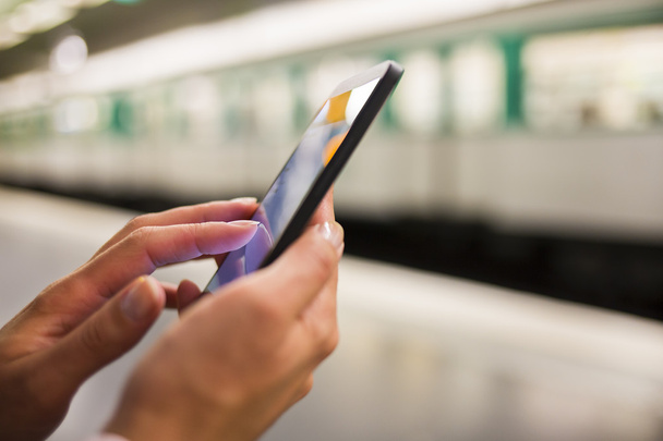 Woman using her smart phone in the subway - Foto, imagen