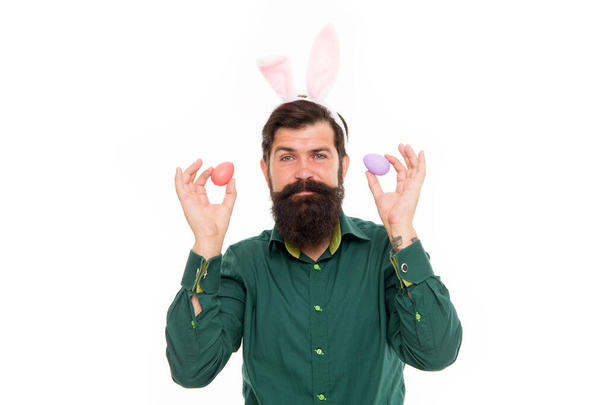 Easter bunny colored eggs. Holiday accessories. Celebration of spring holiday. Bearded man with bunny ears and Easter eggs. Hipster with long ears holding egg. Culture customs and traditions - Foto, immagini