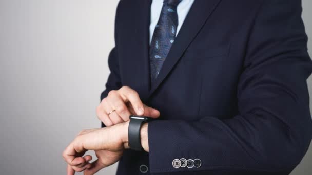 Homem de negócios elegante e bonito com um fato a usar um smartwatch. gerente afiado, chefe está usando um gadget em sua mão. Inteligente
 - Filmagem, Vídeo
