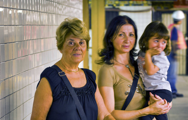 Kobieta w miejskim metrze z córką i wnuczką. Pojęcie podróży i rodziny. - Zdjęcie, obraz