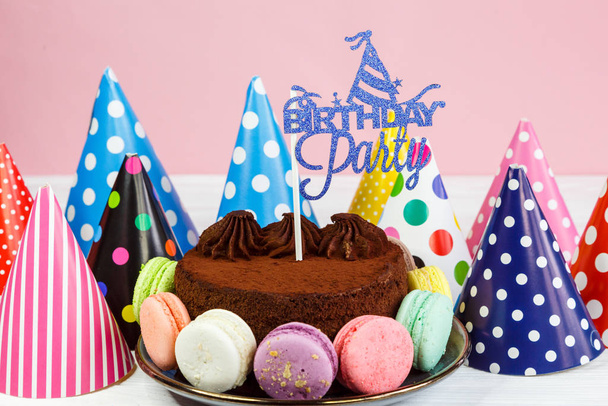 Cholocalizza deliziosa torta con cappelli intorno con topper Festa di compleanno sul tavolo. Da vicino.. - Foto, immagini
