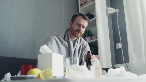 Uomo malato versando farmaci o sciroppo antipiretico al cucchiaio e bevendolo
 - Filmati, video