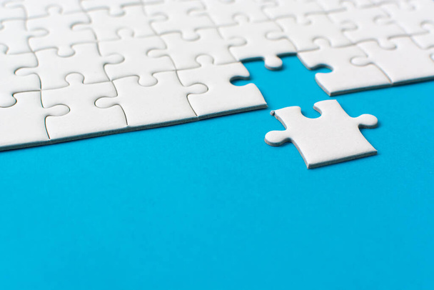 Białe puzzle na niebieskim tle. Partnerstwo sukcesu biznesowego zespołu lub praca zespołowa. - Zdjęcie, obraz