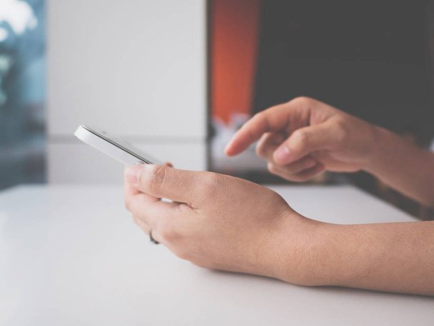 Kadın el ele tutuşup beyaz cep telefonuna dokunuyor. Akıllı telefonda uygulama yazma mesajı kullanıyor. - Fotoğraf, Görsel