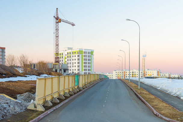 bouw van monolithische openbare en residentiële gebouwen met behulp van torenkranen bouwlawaai in een woonwijk - Foto, afbeelding