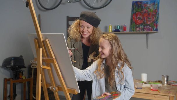 Fille heureuse et femme peindre un tableau
 - Photo, image