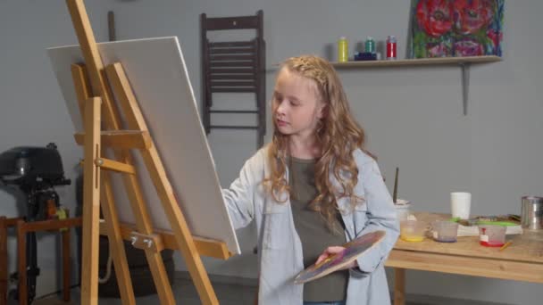 Girl draws a picture on the canvas, slow motion - Video