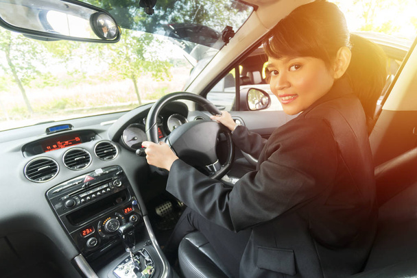 Söpö aasialainen tyttö auton sisällä hymyilee ja katsoo kameraa, e-preiling käsite
 - Valokuva, kuva