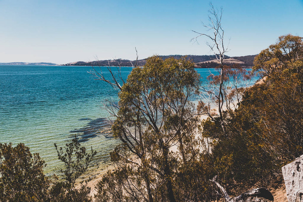 wild Tasmanian landscape and pristine turquoise water of the Derwent River as seen from Legacy Beach walking track near Coningham beach south of Hobart - Fotografie, Obrázek