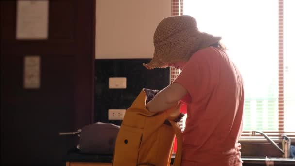 Tanımlanamayan odaklanmış bir kadın evde sırt çantası taşıyor. - Video, Çekim