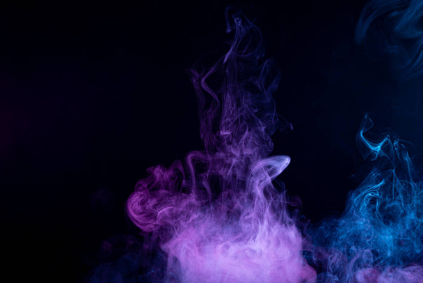 АРТ для вашего дизайнерского проекта. Прозрачный творческий подход. Абстрактный розово-голубой дым на черном изолированном фоне. Остановить движение разноцветного дыма на темной backgroun
 - Фото, изображение