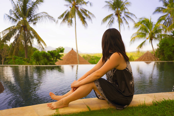 outdoors lifestyle photo of young attractive and relaxed woman enjoying happy the beautiful view from tropical resort infinity pool in exotic luxury holiday and travel destination concept - Fotografie, Obrázek