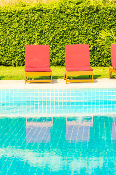 Krásná prázdná židle kolem venkovního bazénu v hotelovém resortu pro dovolenou - Fotografie, Obrázek