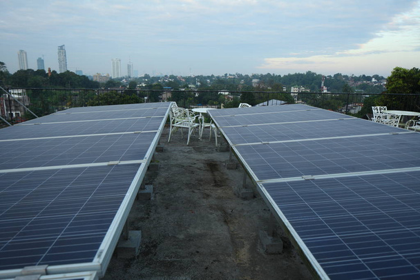 Sabahın erken saatlerinde tropik bir şehir evinin çatısındaki güneş panelleri.. - Fotoğraf, Görsel