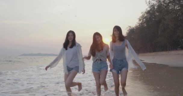 Χαμογελώντας Ευτυχισμένοι ασιάτες φίλοι γυναίκες τρέχουν και πηδούν μαζί παραθαλάσσια στην παραλία καλοκαιρινές διακοπές ηλιοβασίλεμα σιλουέτα dusk διακοπές ταξίδια απολαύσετε τη ζωή δραστηριότητα Σαββατοκύριακο άνθρωποι τρόπο ζωής, Αργή κίνηση 4K  - Πλάνα, βίντεο