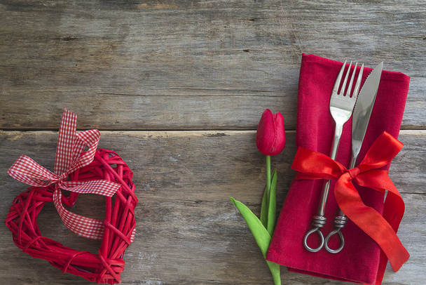 Romantische tafelschikking. Gesmeed vork en mes op rode servet - Foto, afbeelding